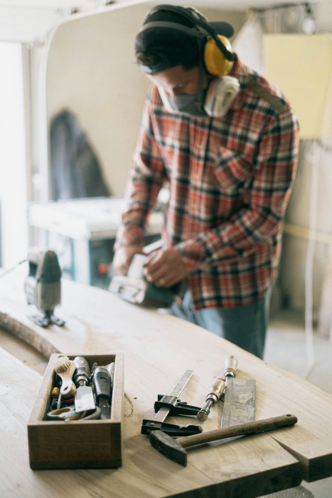hombre midiendo una tabla de madera